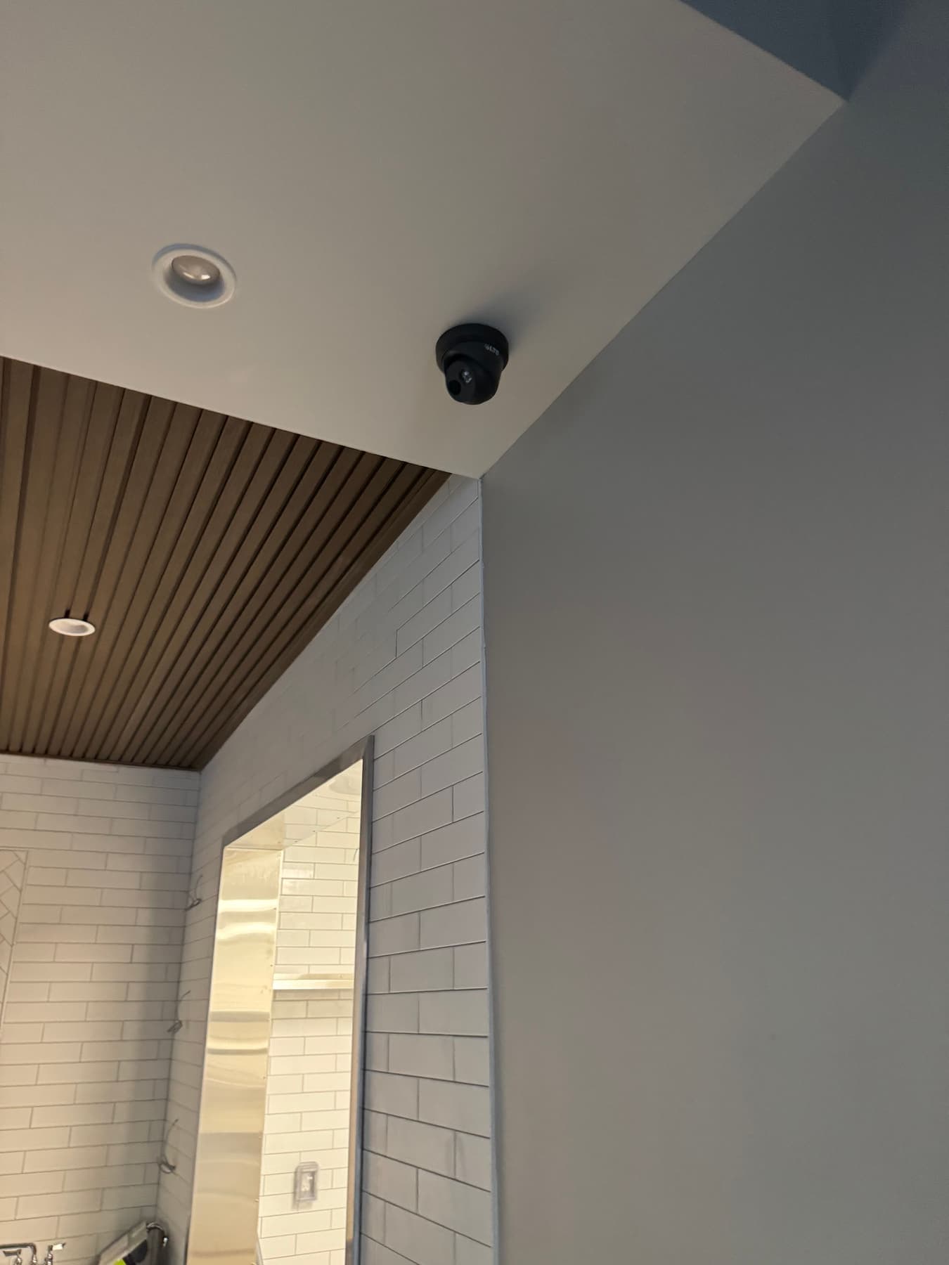 Dome security camera mounted in a wood slat ceiling at a Dallas business